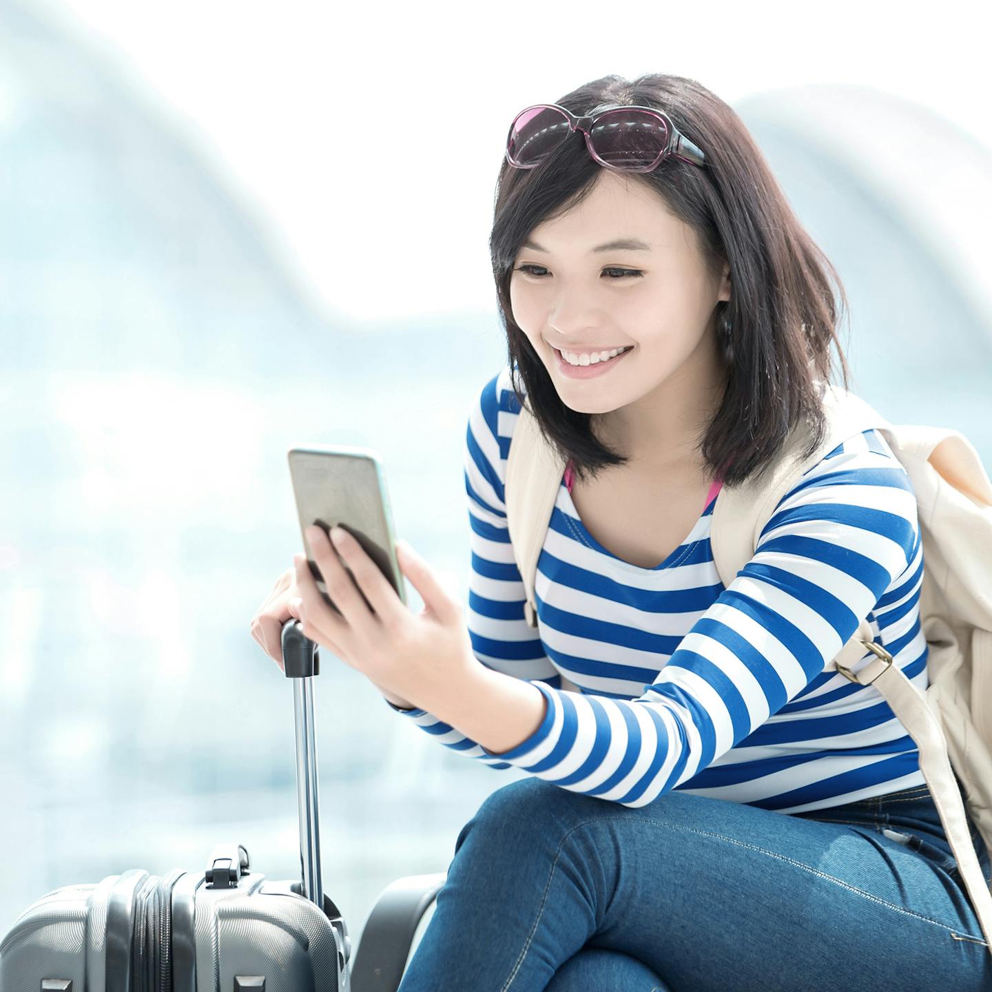 Woman using Voyage full digital commerce platform to book and pay, add ancillary, change flights and check-in on a responsive website or a native mobile app.